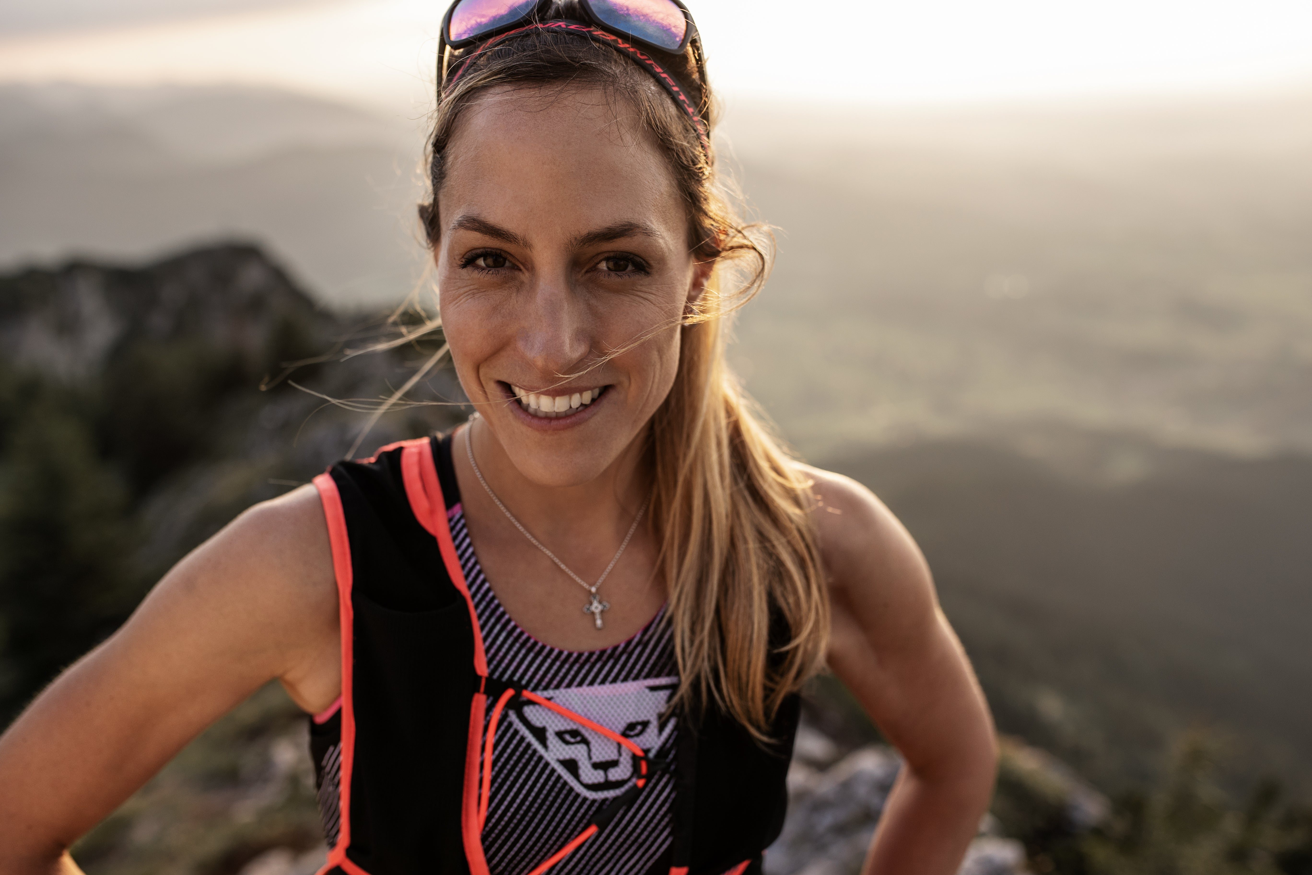 Extremsportlerin Gela Allman steht lächelnd vor einem Bergpanorama