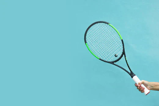 Neuroathletik im Tennis: Eine Hand hält einen Tennisschläger auf blauem Grund