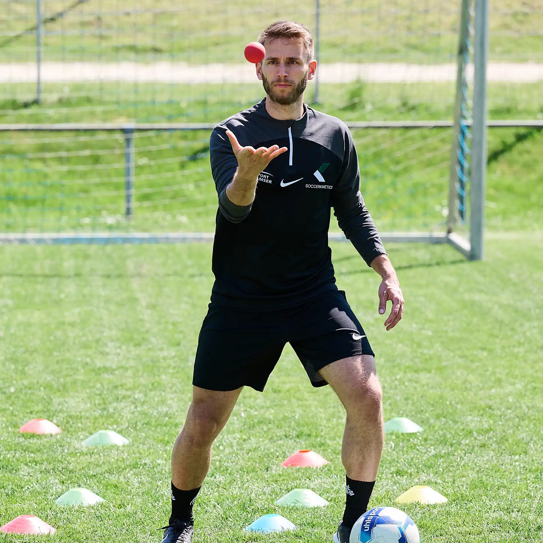 ARTZT neuro BrainBoost Ball – Reaktionsball fürs neurozentrierte Fußballtraining: Simon Jans wirft den Ball auf dem Platz hoch