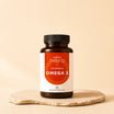 ARTZT neuro Omega 3 Kapseln – Nahrungsergänzungsmittel aus Algenöl, 60 Kapseln in Braunglasflasche auf Steinsockel, warmer beiger Hintergrund | KI-generierte Grafik