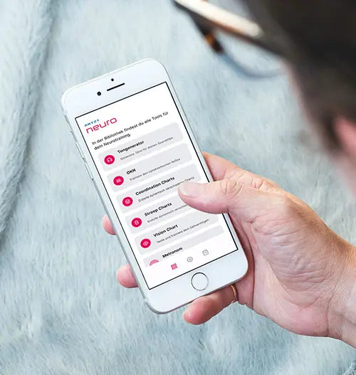 Großaufnahme eines weißen Smartphone in der Hand einer Frau, auf dem die Neuroathletik App neurally läuft.