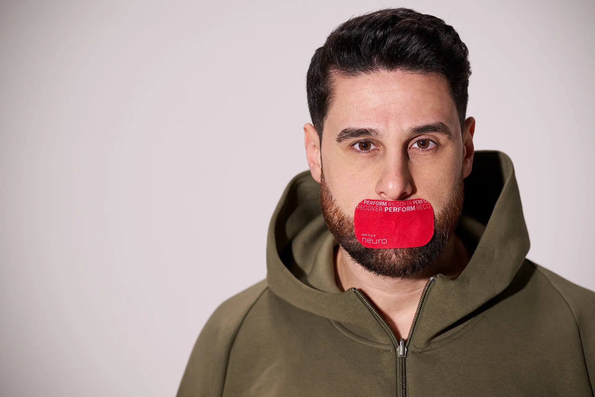 Mann trägt ein rotes ARTZT neuro Mouth Tape Performance auf dem Mund.