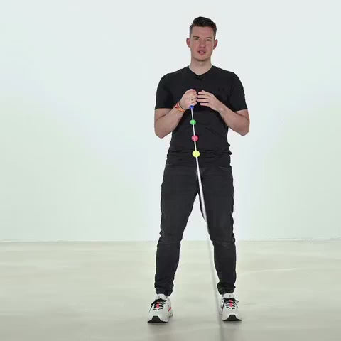 Ein Mann steht vor weißem Hintergrund und hält eine ARTZT neuro Brock Schnur in der rechten Hand.