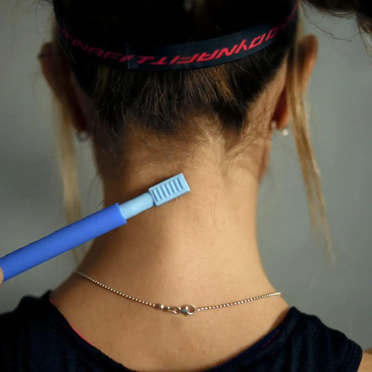 Ein Z-Vibe Vibrationsstift wird in Nahaufnahme an den Nacken einer Frau gehalten