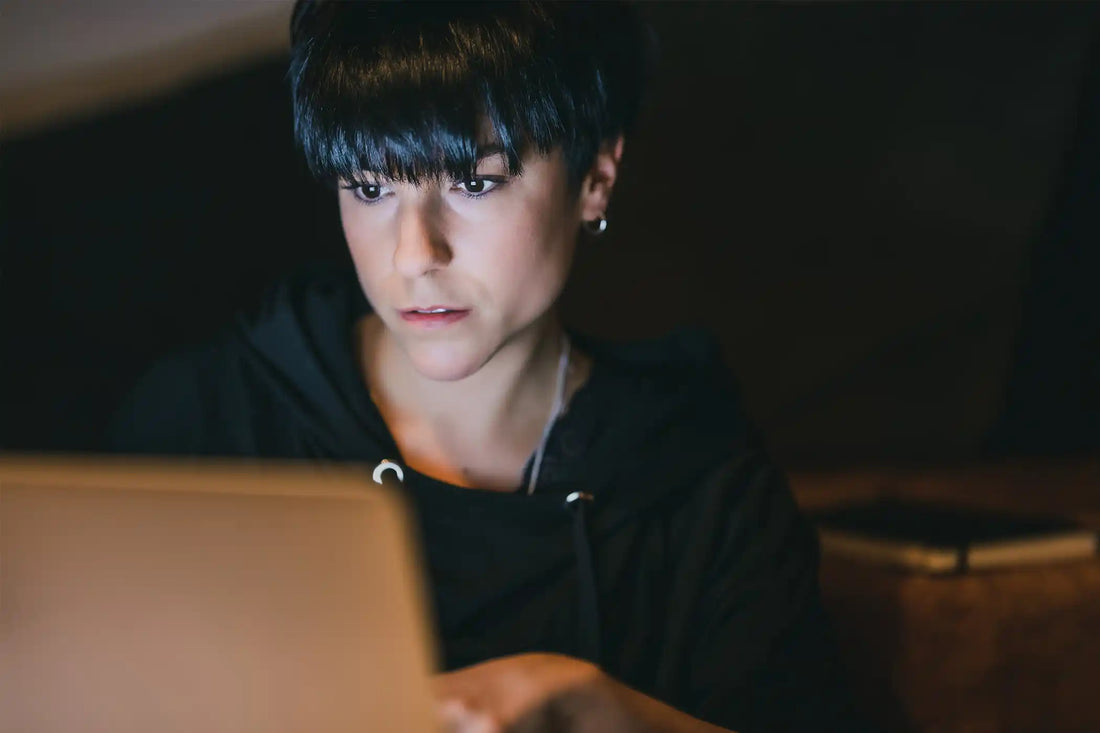 Frau schaut konzentriert auf einen Laptop