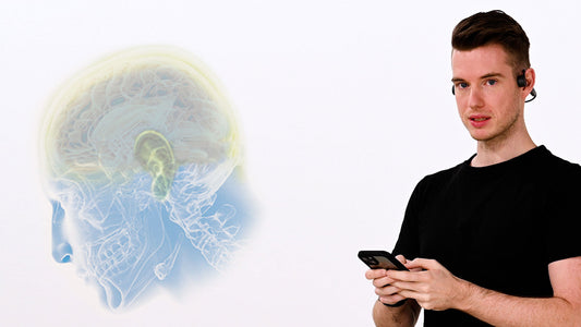 Neuroathletik Trainer trägt den ARTZT neuro SoundVibe Kopfhörer und hält ein Smartphone in beiden Händen
