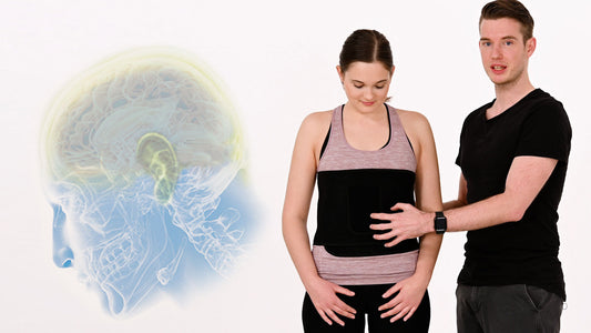 Neuroathletiktrainer Kevin Grafen hält unterstützend den Bauch einer Frau, die den ARTZT neuro Atemgürtel um Taille trägt.