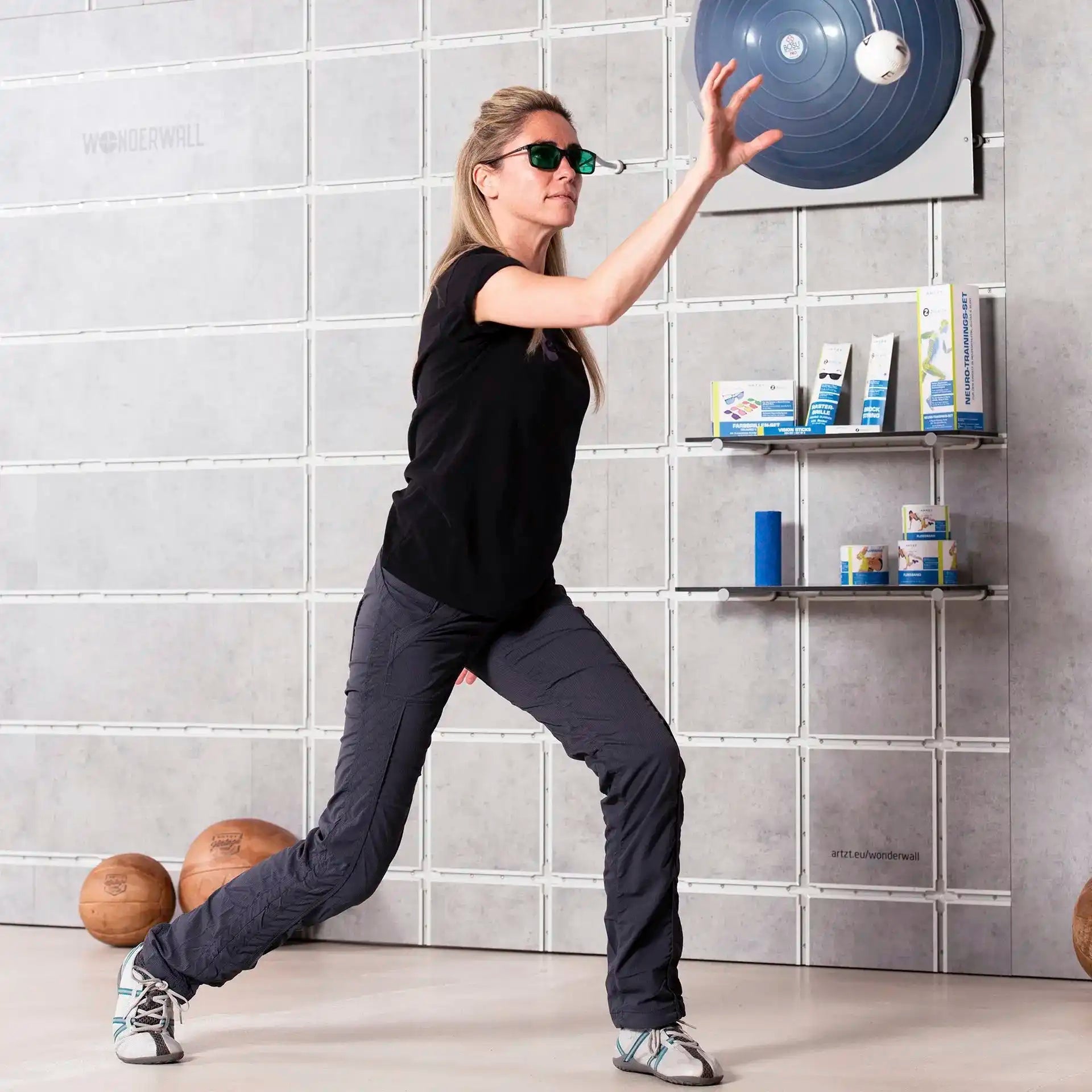 Frau trainiert im Gym mit der grünen Farbbrille von ARTZT neuro und Marsden Ball