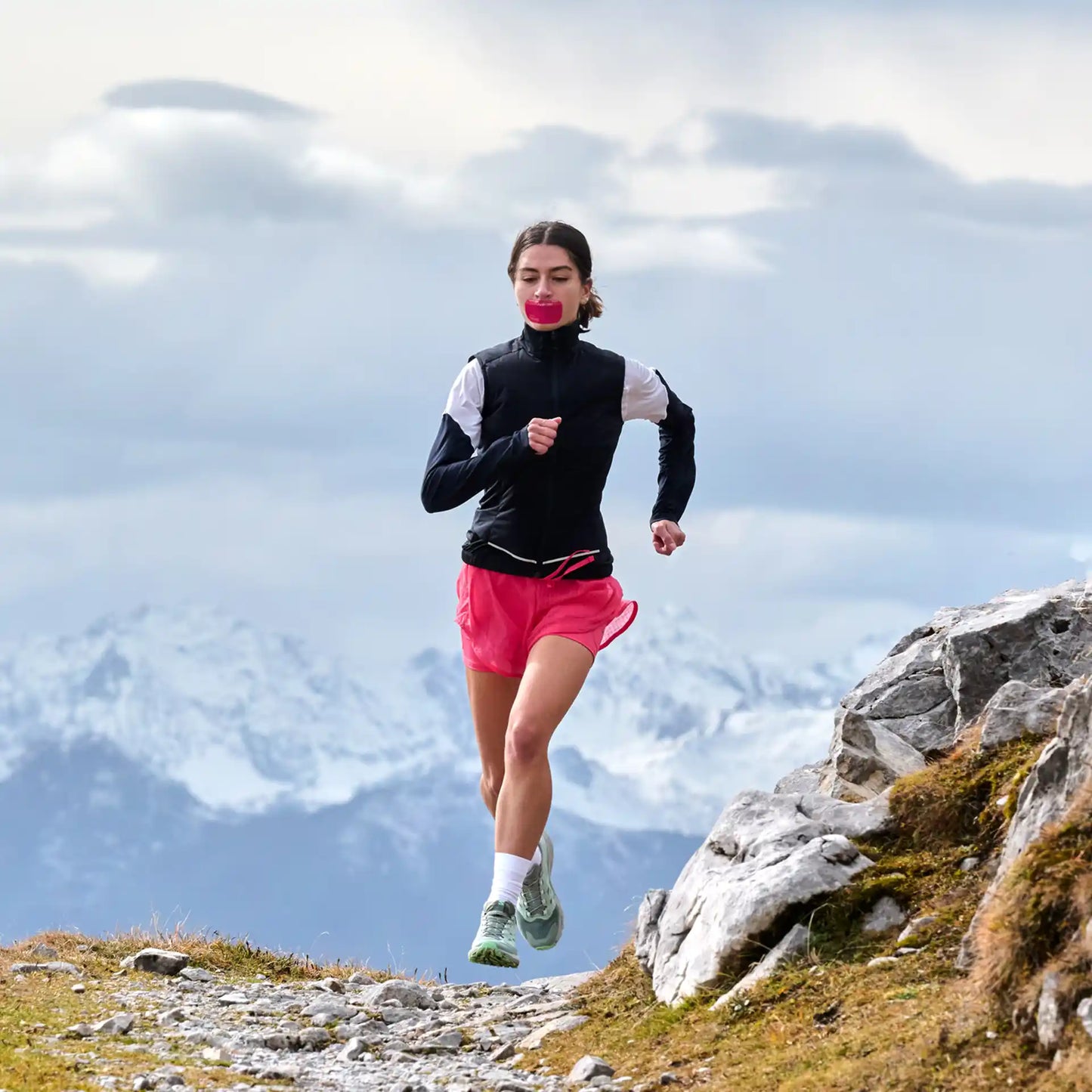 Frau beim Trailrunning in den Alpen mit dem ARTZT neuro Mouth Tape Performance