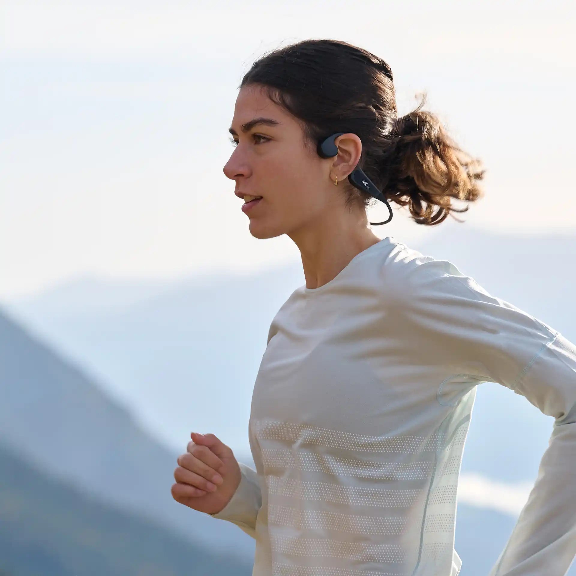 Frau beim Trailrunning mit dem SoundVibe II Knochenschall Kopfhörer ARTZT neuro