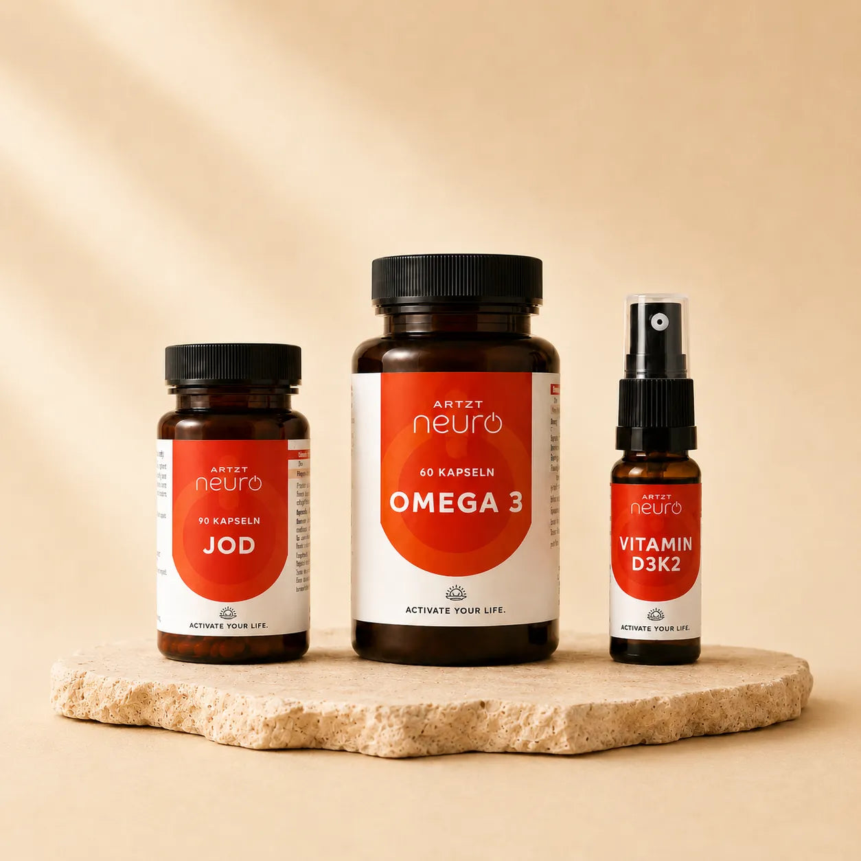 ARTZT neuro Basisversorgung: Omega 3 Algenöl, Jod und Vitamin D3K2 Spray auf Steinsockel – drei Nahrungsergänzungsmittel, warmer beiger Hintergrund
