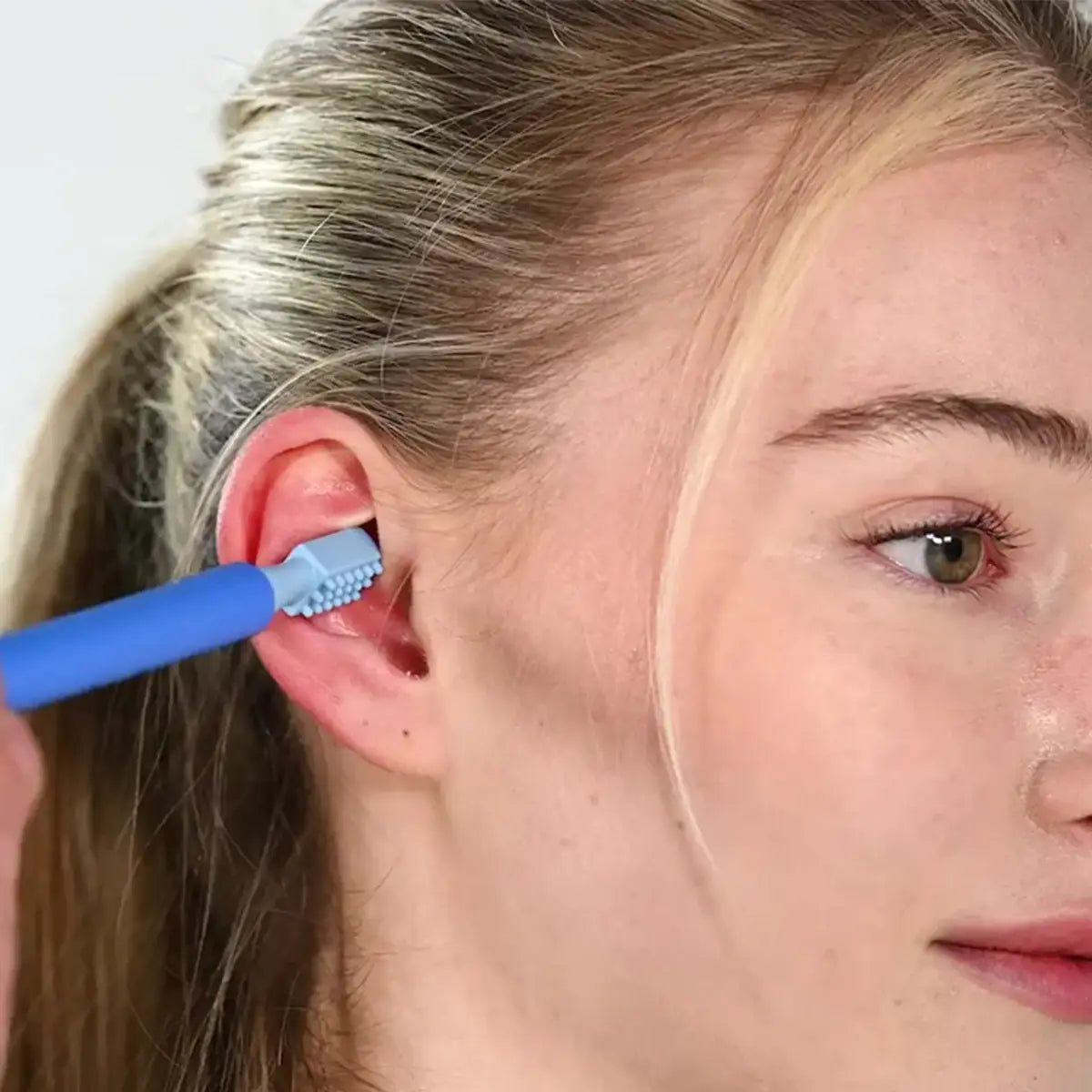 Nahaufnahme eines Z-Vibe Vibrationsstifts, der zur Vagusnerv Stimulation an das rechte Ohr einer Frau gehalten wird.