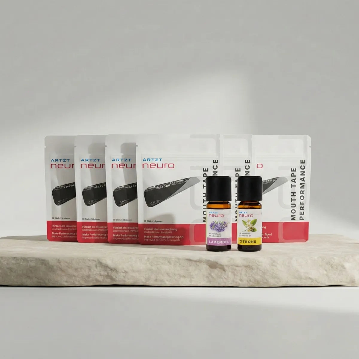 Produktaufnahme des ARTZT neuro Your Focus Breathing Set mit sechs Packungen Mouth Tape Performance, zwei ätherischen Ölen (Lavendel und Zitrone) sowie einem einzelnen Mouth Tape auf hellen Steinplatten vor neutralem Hintergrund. SET-1024, SET-1025 #mengenrabatt_6 monate